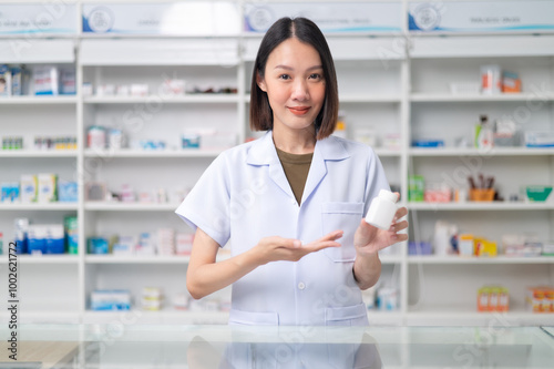 Asian professional female pharmacist standing with arms crossed looking at camera charming smile pointing hand to pill bottle health care products in pharmacies Close-up and wide-angle shots Free Download Asian professional female pharmacist standing with arms crossed looking at camera charming smile pointing hand to pill bottle health care products in pharmacies Close-up and wide-angle shots - GFXLoad
