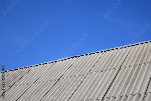 New asbestos roof with clean lines under a bright blue sky