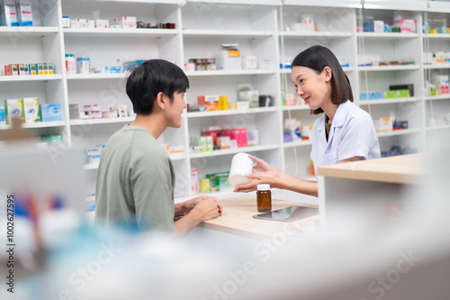 Asian professional female pharmacist using a digital tablet computer to dispense prescription medication to male customers. The doctor advises and explains to the client about the medication.