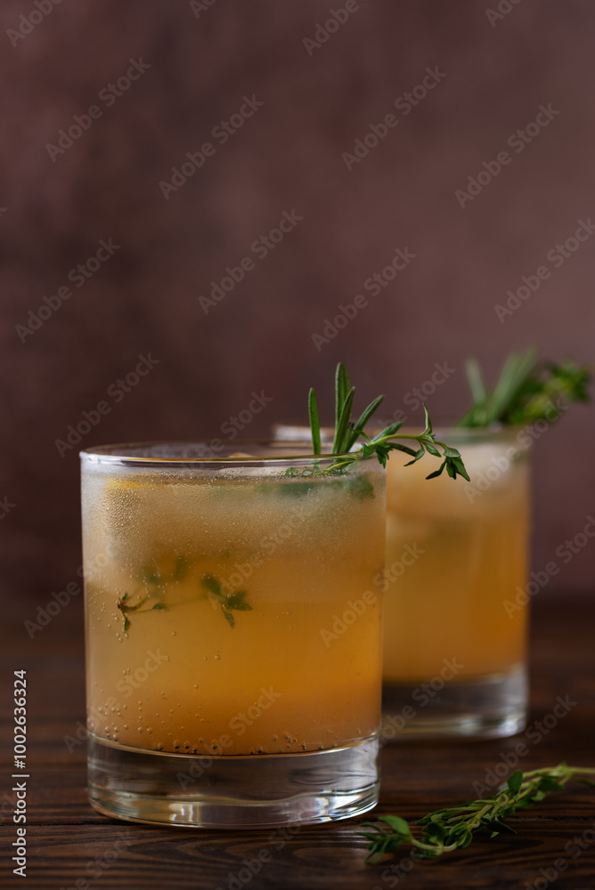 Pear drink lemonade with lemon, rosemary, thyme and ice on a wooden table. Healthy drink, sugar and alcohol free. Vertical orientation. Pear drink lemonade with lemon, rosemary, thyme and ice on a wooden table. Healthy drink, sugar and alcohol free. Vertical orientation.