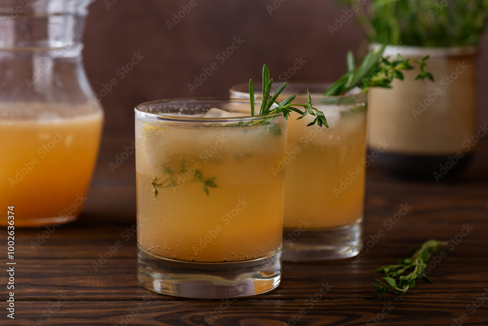 Homemade pear drink lemonade with rosemary, thyme and ice in a glasses on a wooden table. Healthy drink, sugar and alcohol free. Homemade pear drink lemonade with rosemary, thyme and ice in a glasses on a wooden table. Healthy drink, sugar and alcohol free.