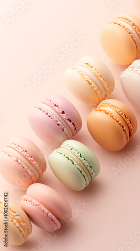 A row of colorful macarons on a pink background. The macarons are arranged in a row, with each one having a different color. Concept of variety and diversity