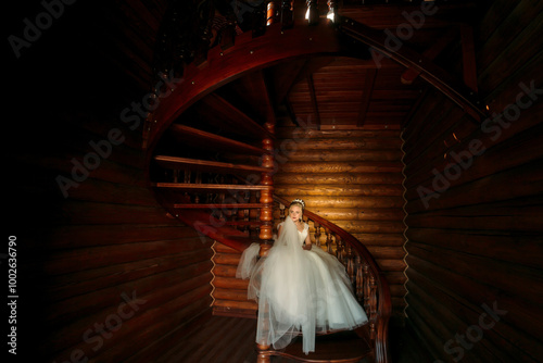 A young girl in a white dress is standing on a spiral staircase