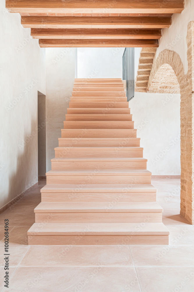 Fototapeta premium Modern wooden staircase features minimalist design and natural light in a spacious interior setting during the daytime