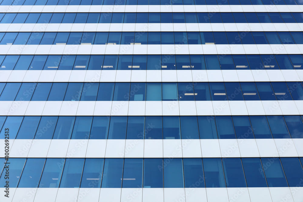 Perspective view from below on office building facade, modern skyscraper. Blue toned glass and steel constructions. Horizontal abstract background, image with place for text.