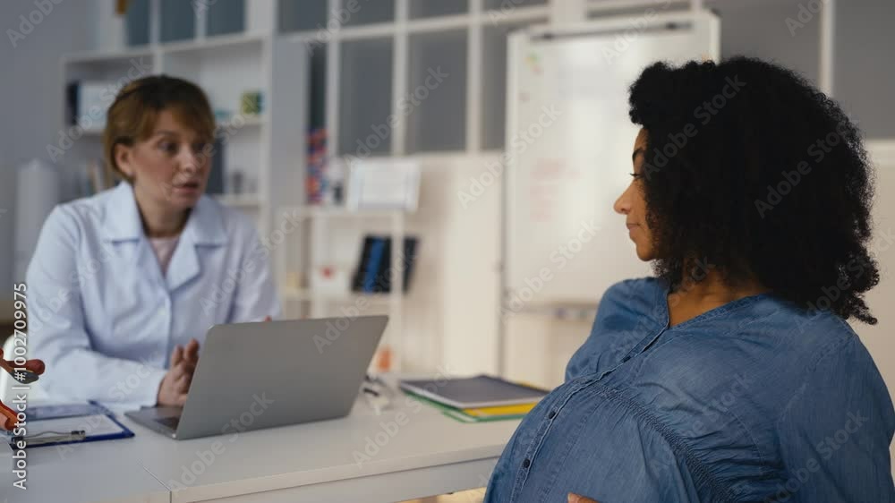 Woman expecting a baby consulting with gynecologist in clinic, healthcare Woman expecting a baby consulting with gynecologist in clinic, healthcare