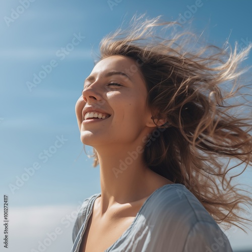 Beautiful woman in nature with eyes closed and head up, enjoying fresh air with blue sky background