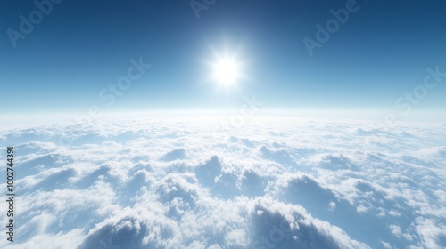 A high-altitude view of sparse clouds with a rich blue sky, the sun a white pinpoint of light just breaking the horizon