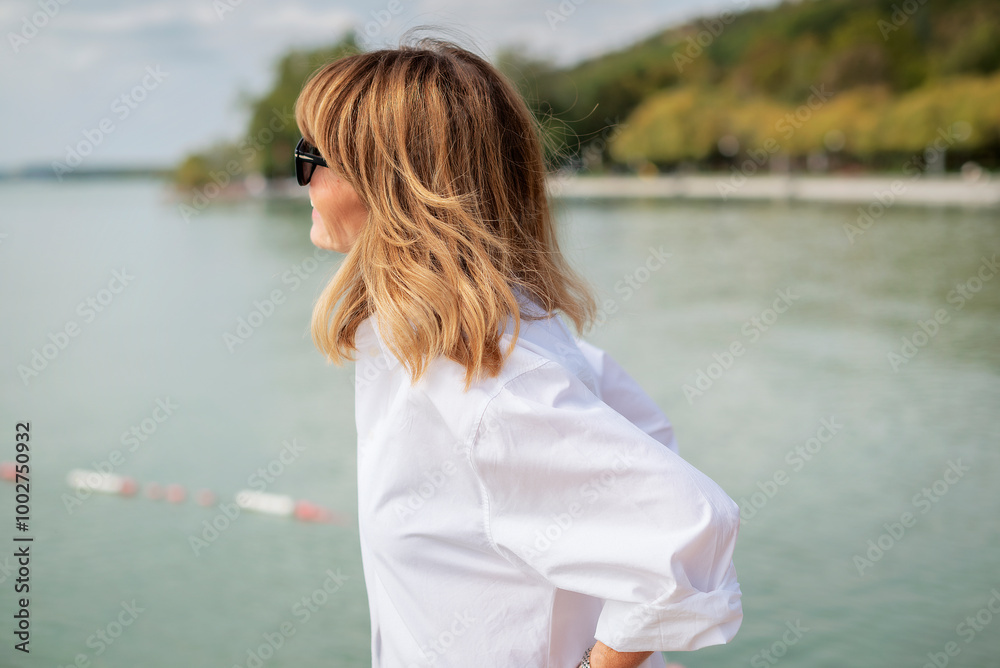 Close-up portrait of an attractive blond haired woman standing by the lake Close-up portrait of an attractive blond haired woman standing by the lake
