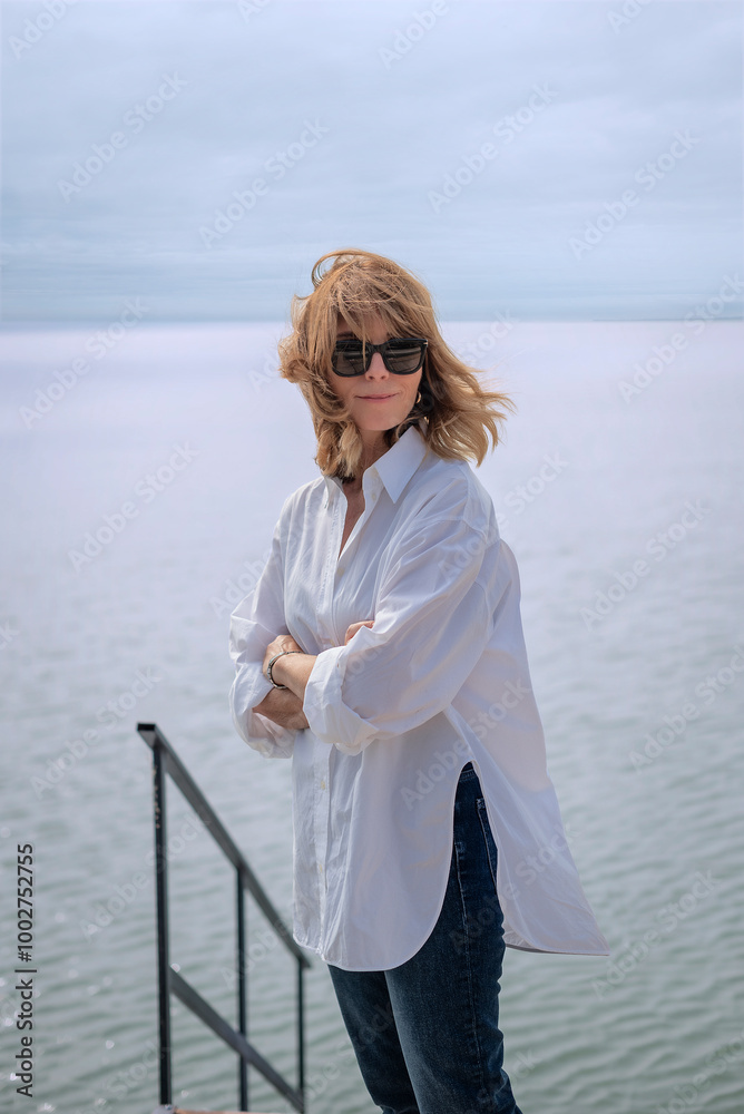 Portrait of a blond haired woman standing by the lake Portrait of a blond haired woman standing by the lake
