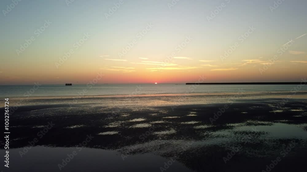 Drone video heading out to sea of the coast of Hunstanton, Norfolk as the sun sets over the ocean horizon. Drone video heading out to sea of the coast of Hunstanton, Norfolk as the sun sets over the ocean horizon.