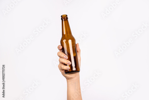 Photo of woman's hand holding bottle of beer isolated on white background. Alcohol concept