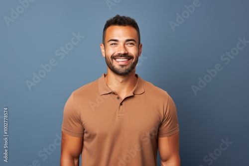 Portrait of a satisfied man in his 30s wearing a sporty polo shirt in blank studio backdrop