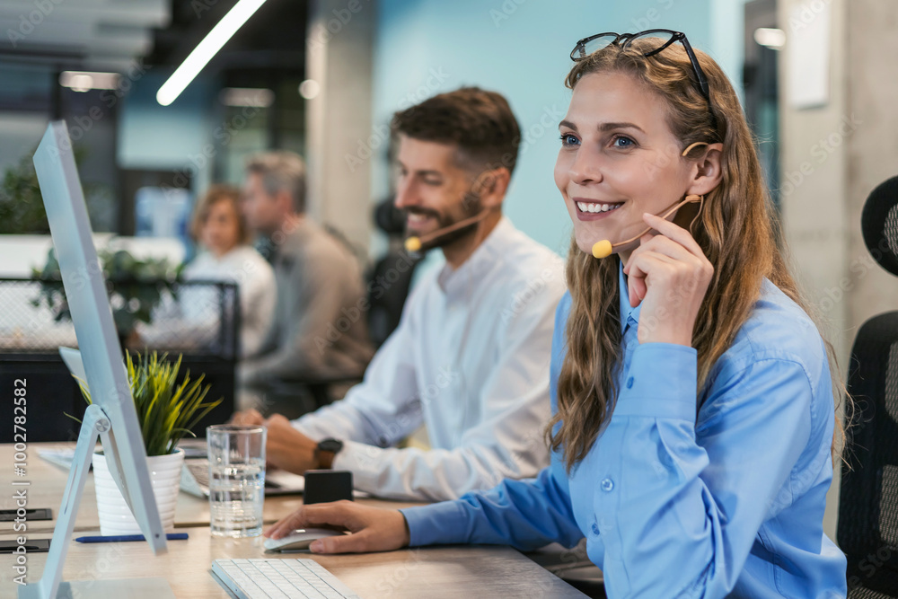 Portrait of call center worker accompanied by her team. Smiling customer support operator at work. Portrait of call center worker accompanied by her team. Smiling customer support operator at work.