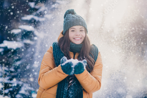 Photo of funny charming school girl dressed outwear coat blowing holding hands arms snowflakes countryside forest