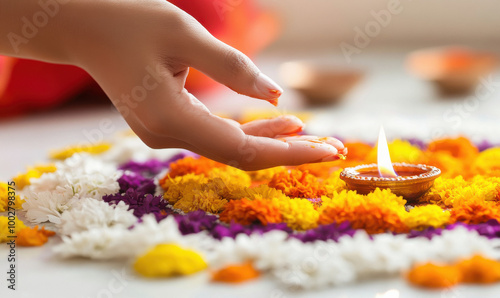 indian female hands lighting a candle on rangoli