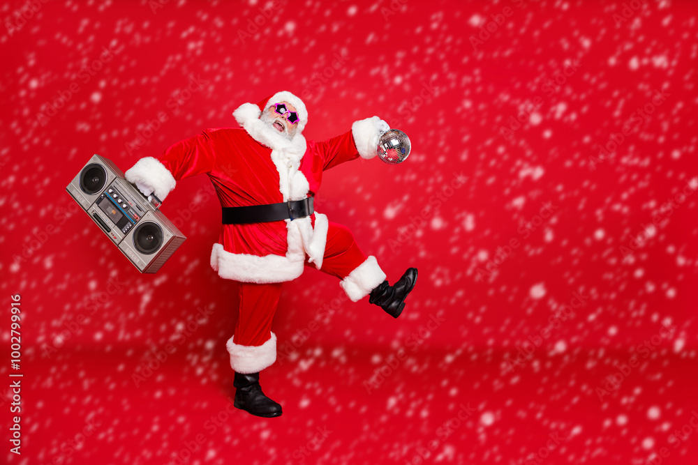 Full length photo of handsome laughing joking active energetic nice comic humorous joking singing jingle bells sants enjoying christmastime holding casette player isolated vivid background Full length photo of handsome laughing joking active energetic nice comic humorous joking singing jingle bells sants enjoying christmastime holding casette player isolated vivid background