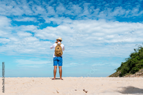 Relax asian man barefoot walking on tropical summer beach feeling fresh and freedom on holiday. Enjoyment barefoot walk outdoor with freedom. Relaxation Travel Concept.