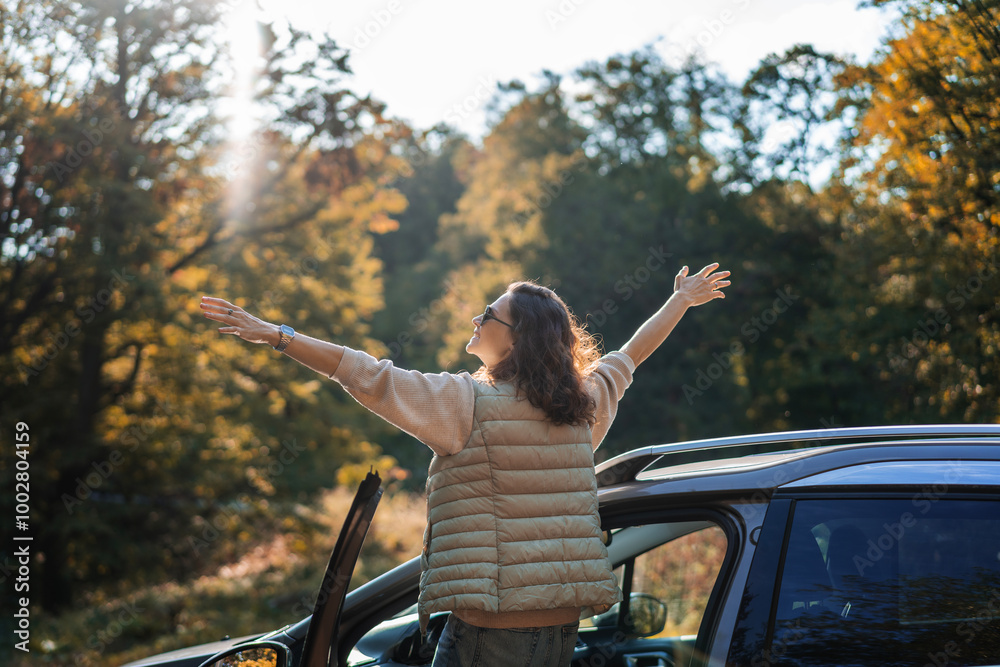 Happy woman driver traveling by car in forest enjoying freedom and nature
