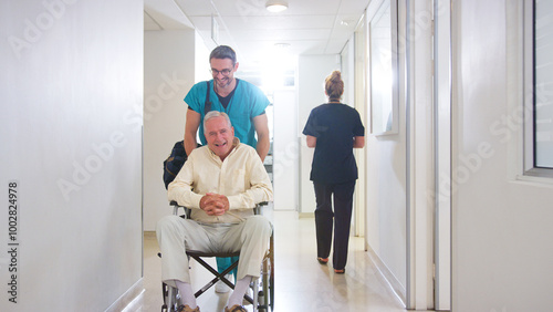 Male Orderly Pushing Senior Male Patient Being Discharged From Hospital In Wheelchair