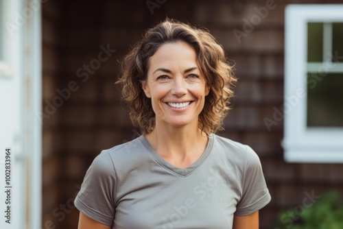 Portrait of a smiling woman in her 40s sporting a breathable hiking shirt in stylized simple home office background photo