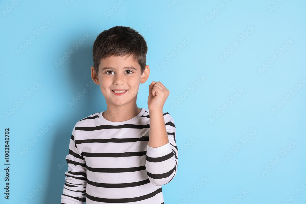 Portrait of cute little boy on light blue background, space for text Portrait of cute little boy on light blue background, space for text