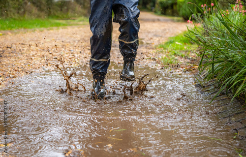 Foto Child in welly boots, jump, jumping in mud.