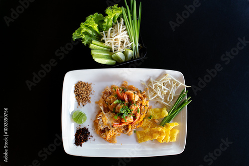 Fried rice noodle with shrimp in white plate on black background