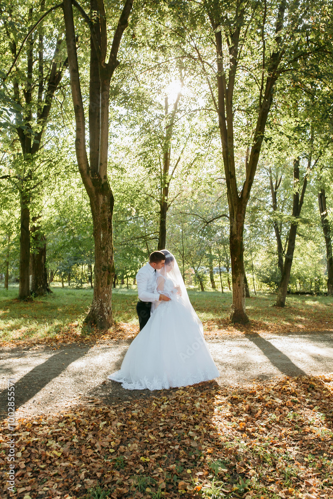A bride and groom are standing in a forest, surrounded by trees and leaves. Scene is romantic and peaceful A bride and groom are standing in a forest, surrounded by trees and leaves. Scene is romantic and peaceful