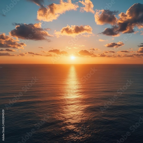 Illustrate a picturesque golden sunset spreading its beauty over a vast ocean from a birds eye view