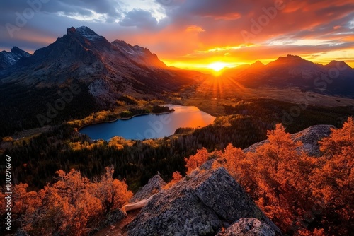 A stunning sunset casts vibrant orange and red hues over a tranquil lake framed by the rich colors of autumn trees and distant mountains creating harmony.