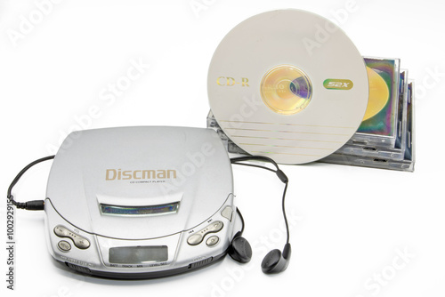 Close-up of a discman with cd cases next to it isolated on white background