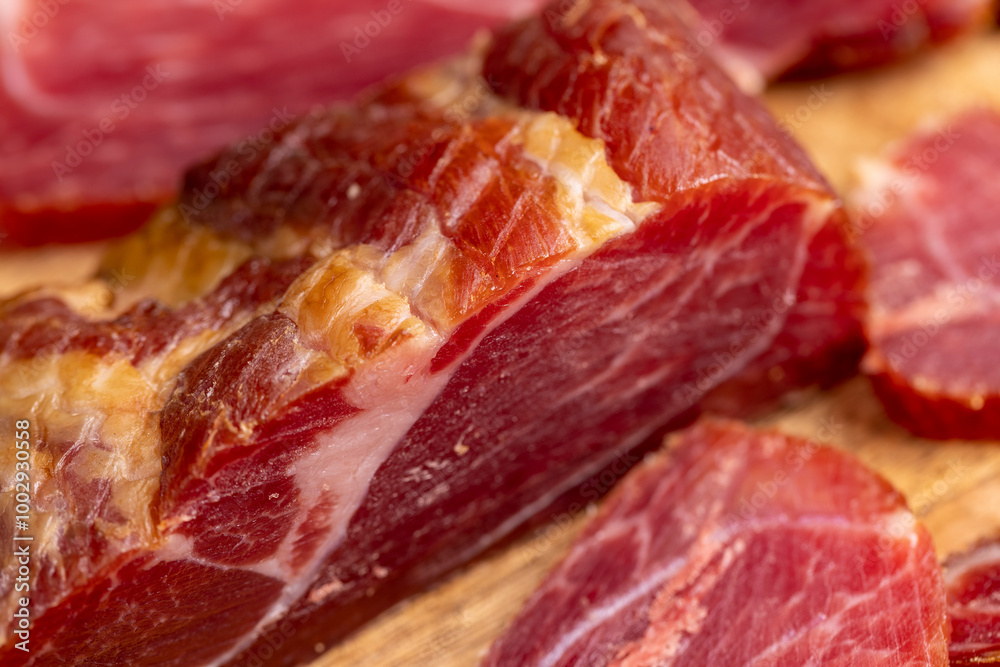 a piece of cured pork ham with thin layers of lard on the table a piece of cured pork ham with thin layers of lard on the table