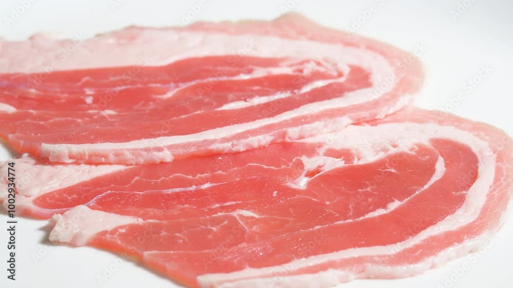 Raw Bacon Slices Rotating Background. Pork Meat with Glistening Fat Marbled Within Succulent Meat. Bacon Strips