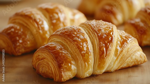 Buttery croissants with a glossy top, close-up shot highlighting the delicate layers and crisp edges, croissant, gourmet breakfast pastry