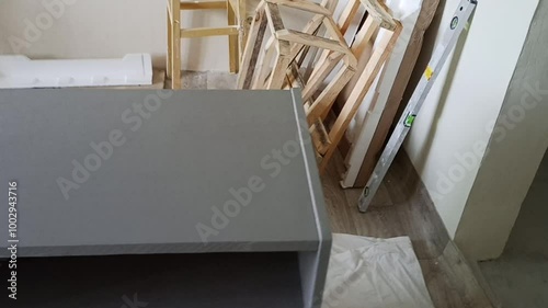 Process of redesigning an old wooden nightstand. A woman sands off the old paint, preparing the surface for a furniture makeover. Perfect for DIY, home improvement, and furniture restoration themes