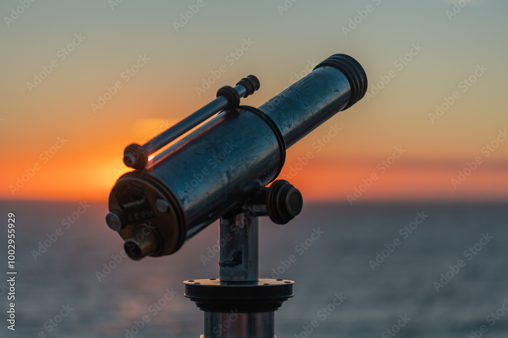 Binoculars at the pier in Scheveningen during sunset. Red glowing sky, warm light, tranquil scene. The Hague, Netherlnds. Binoculars at the pier in Scheveningen during sunset. Red glowing sky, warm light, tranquil scene. The Hague, Netherlnds.