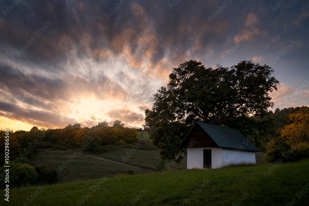 Autumn sunset landscape. Fall scenery with colored sky, trees and leafs. Country chalet near Banska Bystrica in central Slovakia Autumn sunset landscape. Fall scenery with colored sky, trees and leafs. Country chalet near Banska Bystrica in central Slovakia