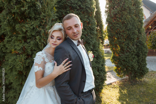 A woman in a wedding dress holding a flower. The dress is white and the woman has a tiara on her head