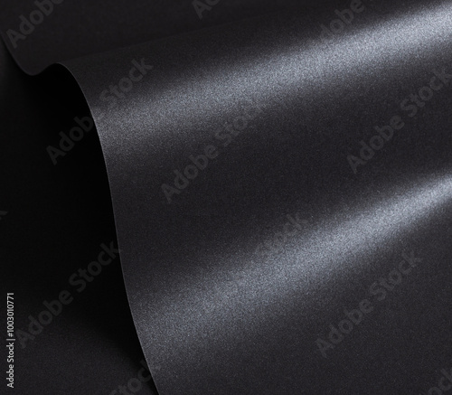 Black paper with a textured surface and minimalist, monochrome background. The premium structure exudes a classy and chic design, featuring dark, elegant waves with a fluid, glossy