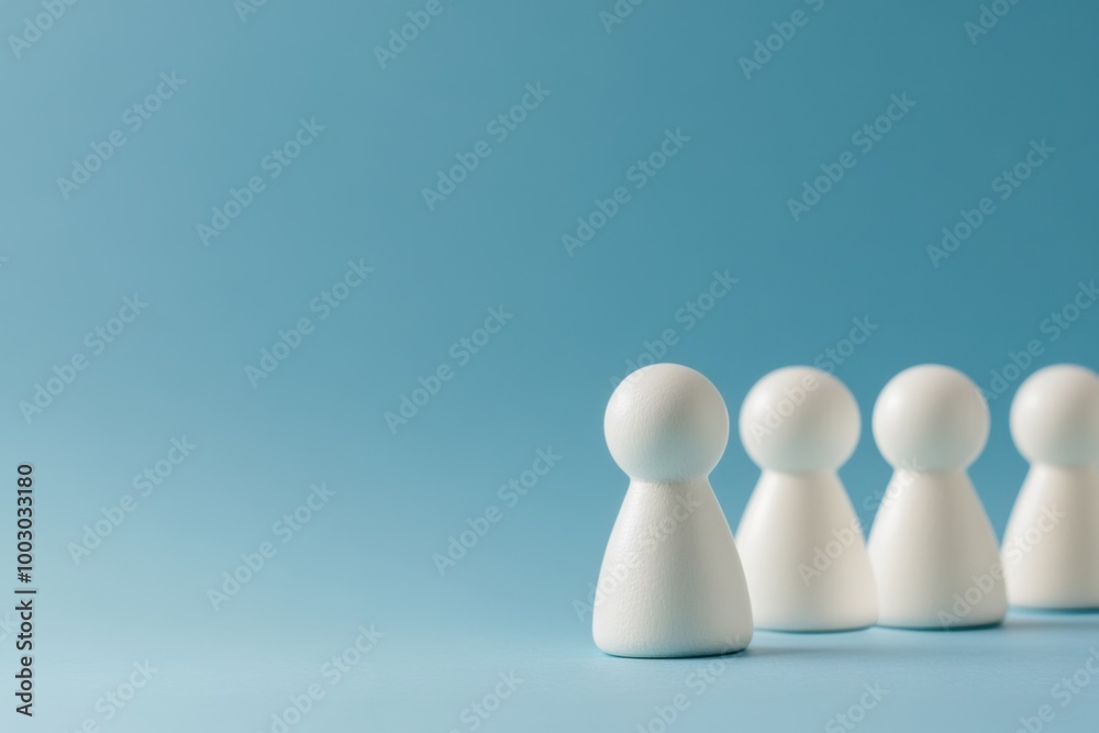 White figurines lined up against a blue background during a minimalistic display of unity and teamwork White figurines lined up against a blue background during a minimalistic display of unity and teamwork