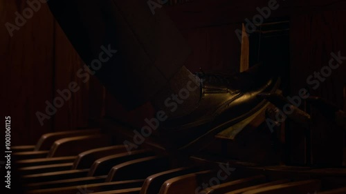 Close-up view of unrecognisable organist in black shoes with right foot on crescendo pedal photo