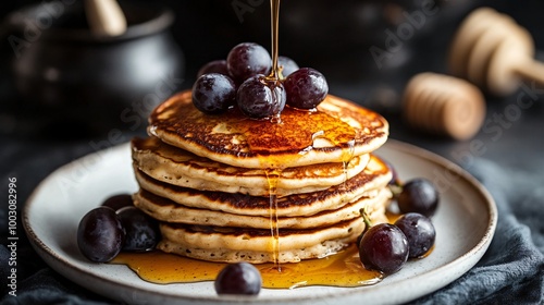 Grape and ricotta pancakes drizzled with honey, displayed on a white plate against a dark industrial backdrop