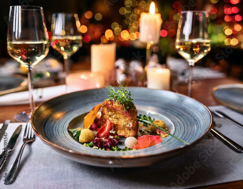 A close-up of a plate of gourmet food in a fine dining restaurant. The dish is artfully arra photo