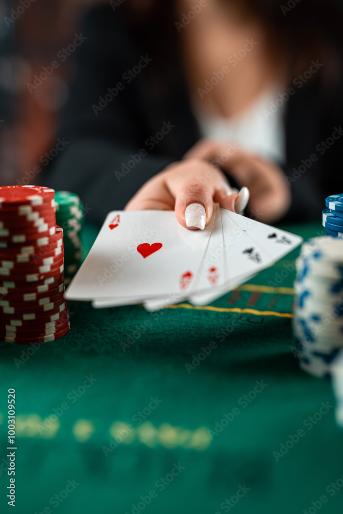 female hand takes poker chips from a pile at a round poker table. risky bets in poker female hand takes poker chips from a pile at a round poker table. risky bets in poker