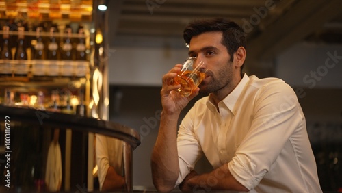 Smart man in white shirt drinking cocktail Old fashioned of special party beverage vibrant waiting for friends or couple at nightclub on Friday meeting night time at luxurious counter bar. Vinosity.