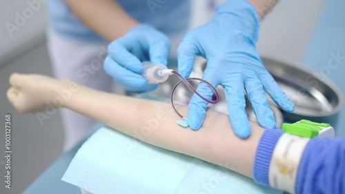 A nurse takes blood from a child using butterfly needle. Close up video of a boy's hand while taking a blood sample for examination in a modern laboratory or hospital. Baby health check