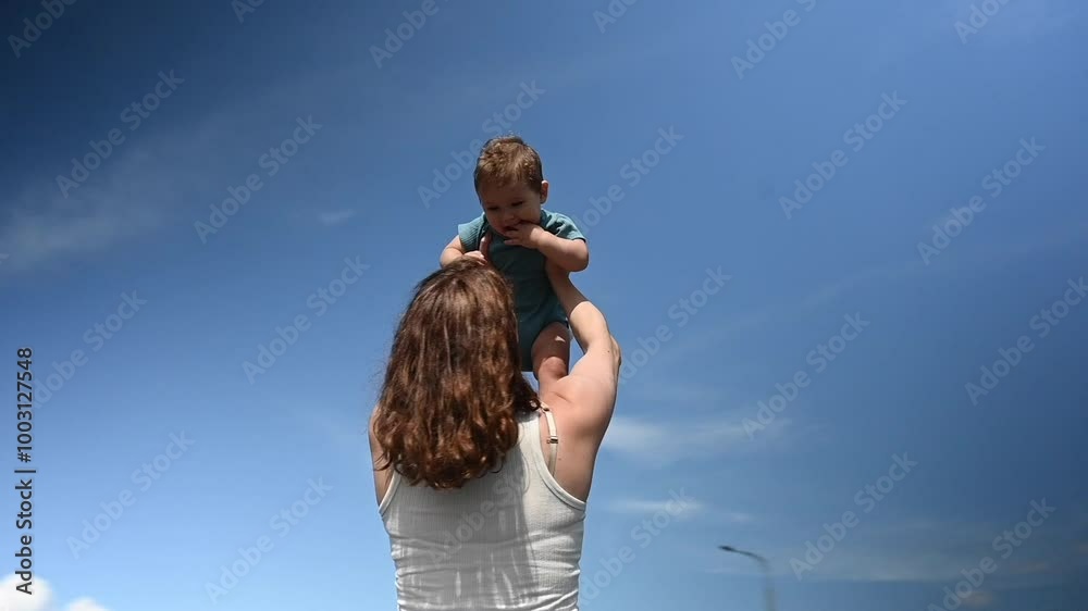 Caucasian woman holds her one-year-old son above her head. 360 degree video. Caucasian woman holds her one-year-old son above her head. 360 degree video.