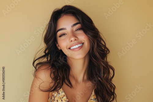 Elegant 30s Latina woman with long wavy hair, wearing a fashionable dress, smiling subtly. Portrait on solid beige background. Ideal for fashion brands, beauty products, lifestyle magazines.