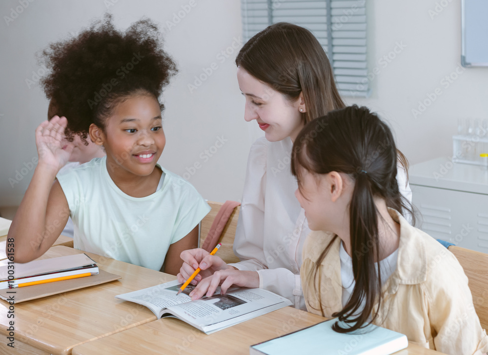Group of adorable kids diverse cultures and Caucasian female teacher in classroom. Teacher helps schoolgirls to teaching they lesson at elementary school. Education concept. Group of adorable kids diverse cultures and Caucasian female teacher in classroom. Teacher helps schoolgirls to teaching they lesson at elementary school. Education concept.
